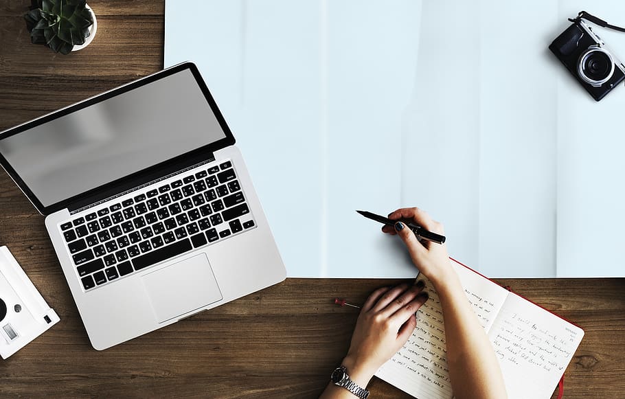 Person Holding Pen Near Macbook Pro, camera, contemporary, desk HD wallpaper