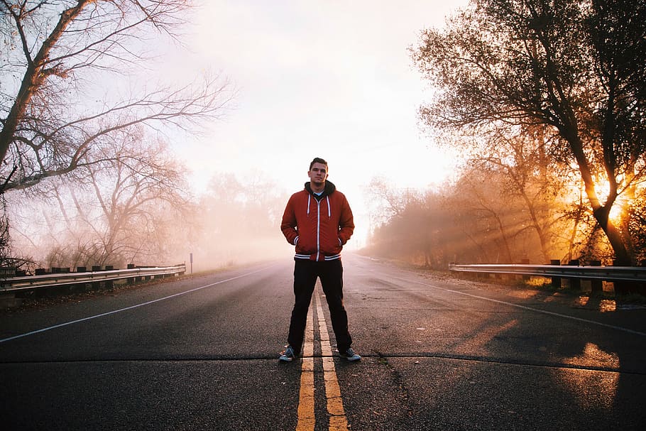 Man Standing on Gray Concrete Top Road Wearing Red and Black Zip-up Hooded Jacket