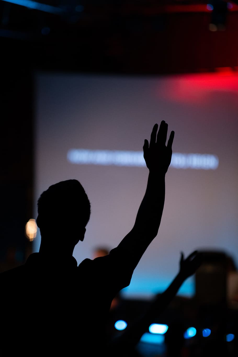 silhouette of person raising hand, hands up, praise, worship
