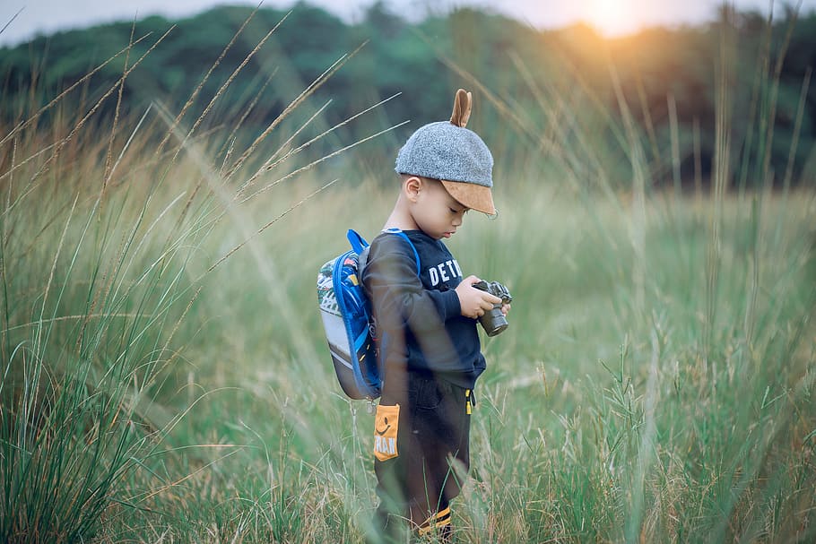 Toddler Holding Camera, boy, child, field, fun, grass, hat, kid HD wallpaper