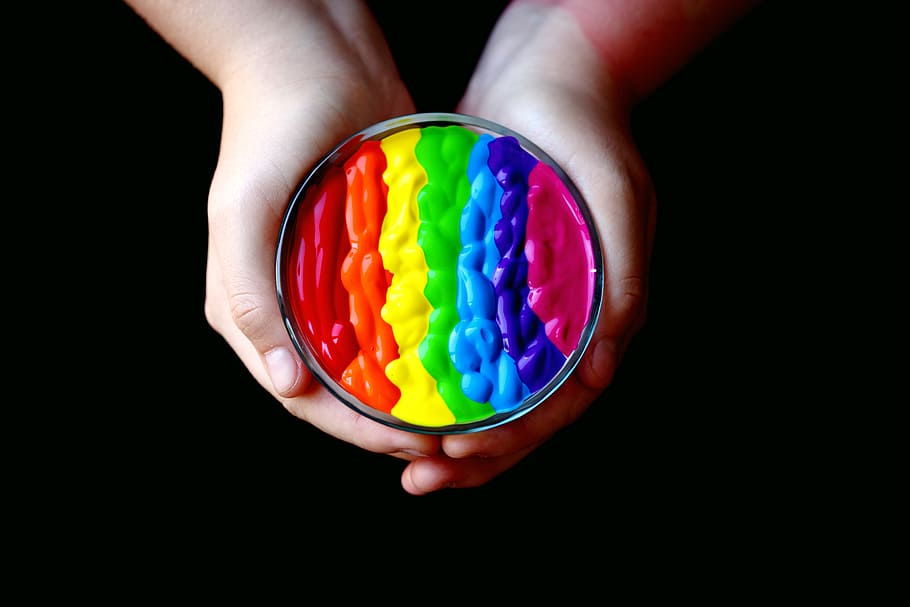 Person Holding Multicolored Container, background, black background