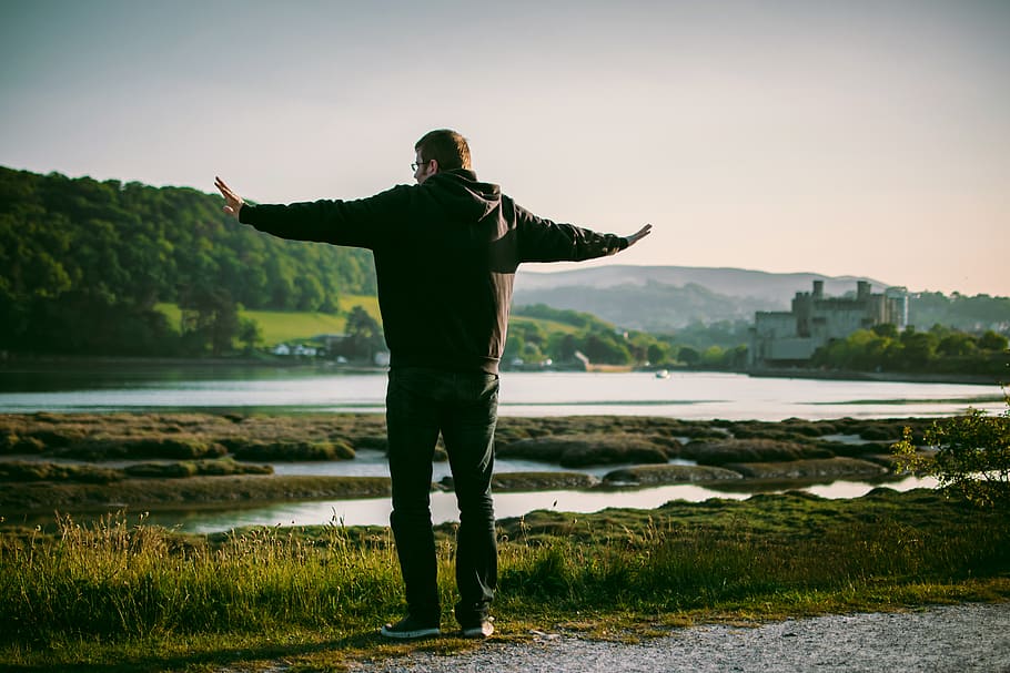 Man Wearing Black Jacket Near on Body of Water, daylight, rock HD wallpaper