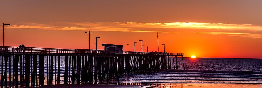 Silhouette of Boardwalk Near Body of Water Under Orange Sunset during Daytime HD wallpaper