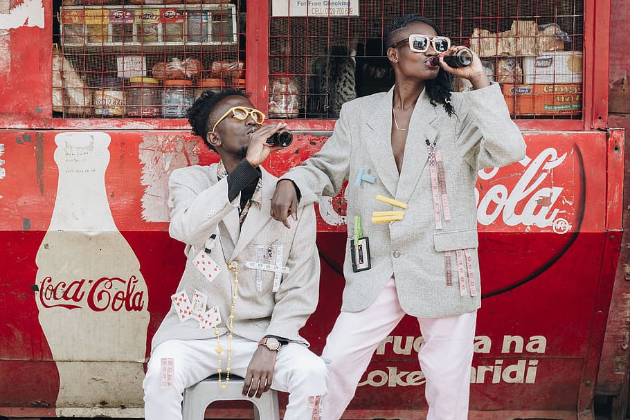 Two Person Drinking Coca-cola Next to a Kiosk, coca cola, fashion