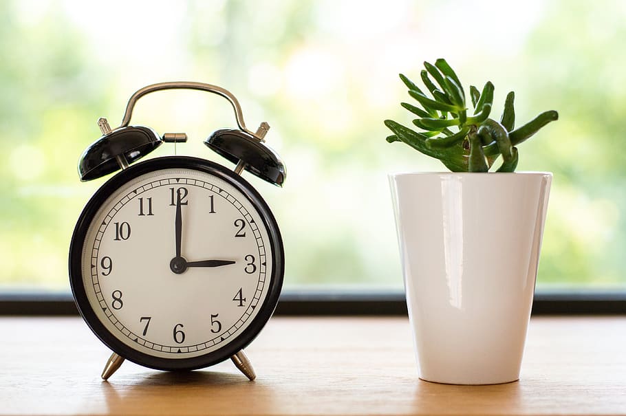 Double Bell Alarm Clock Displaying 3:00 Time, blurred background