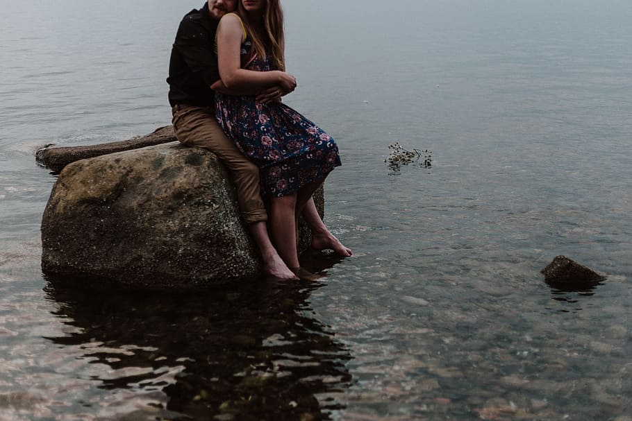man and woman sitting on rock, water, sea, ocean, lake, sat, embrace, HD wallpaper