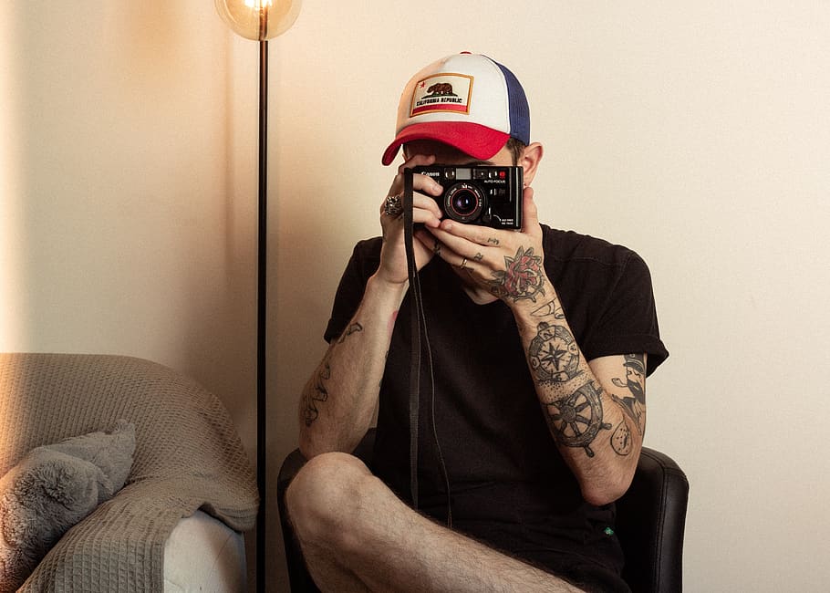 Man Holding Camera, camera lens, chair, close-up, equipment, fashion HD wallpaper