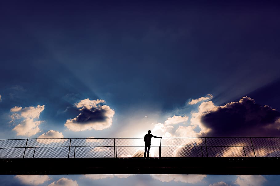 Man In The Middle Of A Bridge, backlit, clouds, daylight, fence HD wallpaper