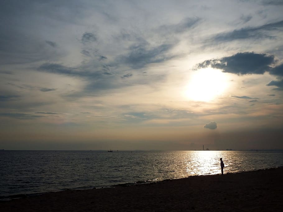 Man silhouetted in sunset sky on a beach next to the ocean, vacation HD wallpaper