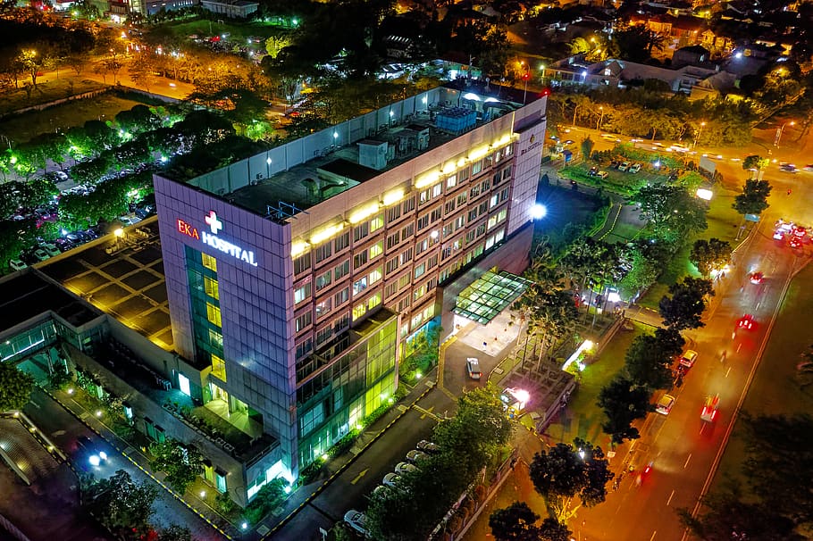 Hospital Beside Vehicle Park and Road at Night, aerial, architecture