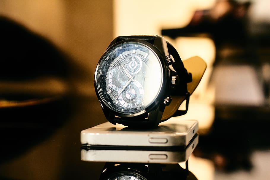 Black Chronograph Watch on Smartphone on Table, blurred background HD wallpaper