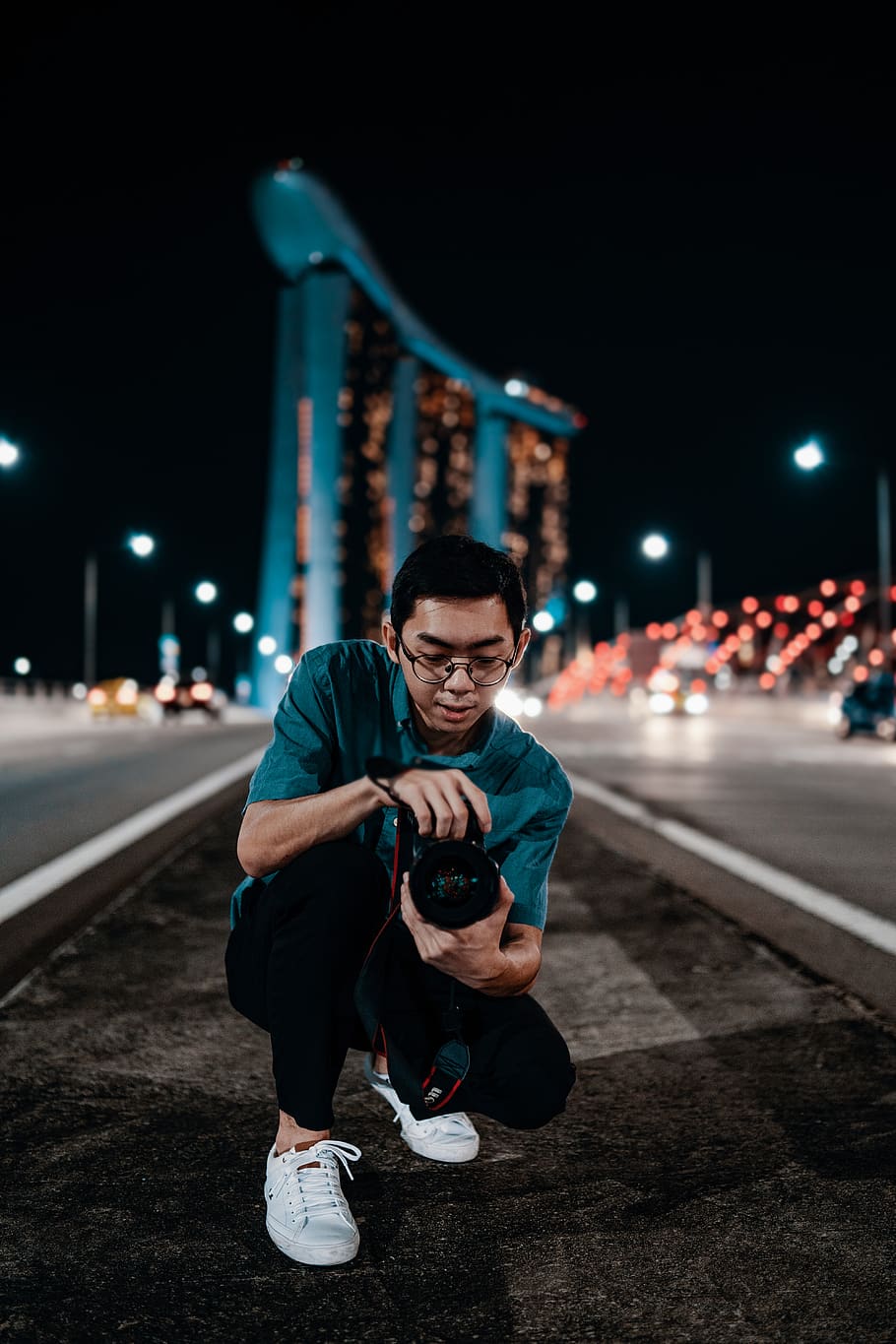 man holding camera during nighttime, human, person, apparel, shoe
