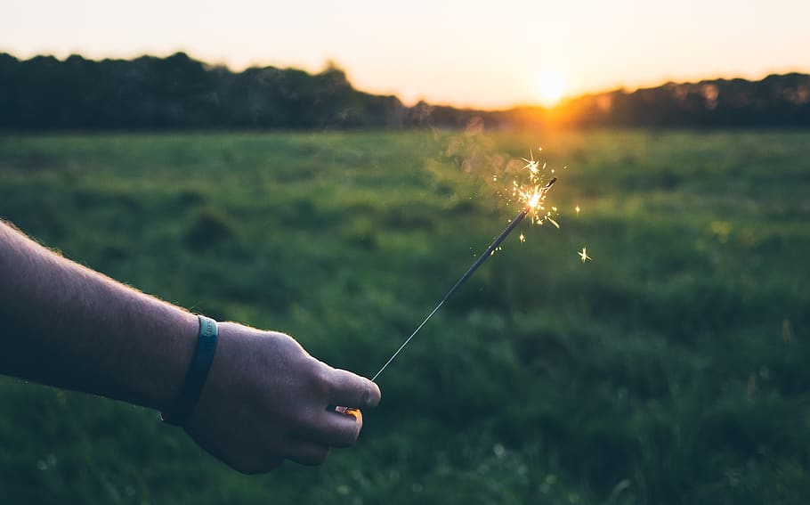 sparkler, lights, fire, flame, hand, green, grass, field, nature HD wallpaper