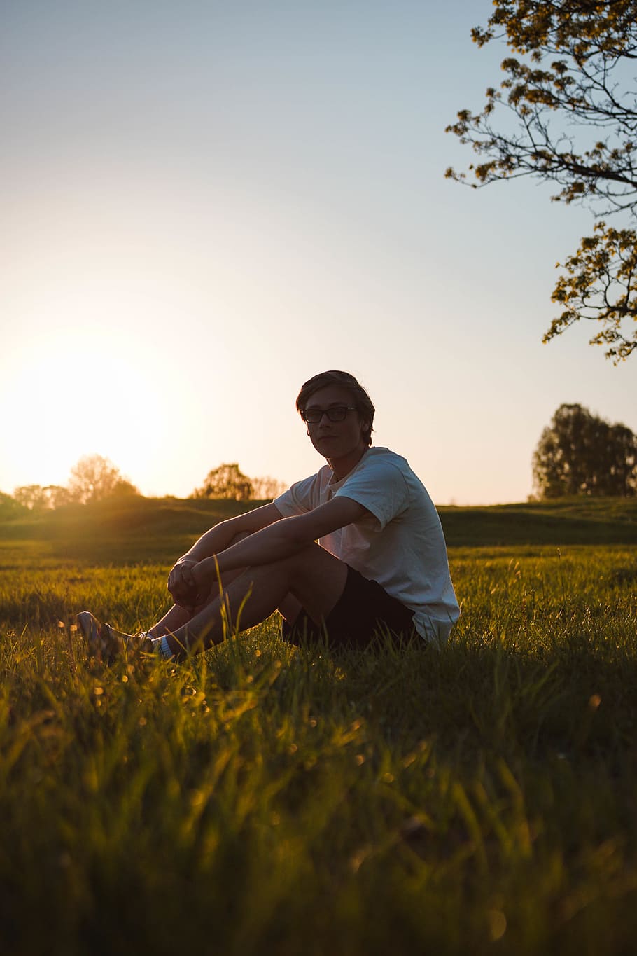 man sitting on grass field during sunset, sky, one person, plant HD wallpaper
