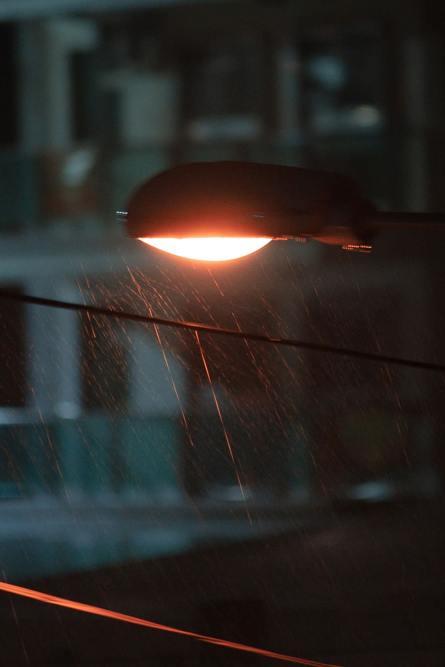 turned-on light post under the rain, no people, motion, focus on foreground HD wallpaper