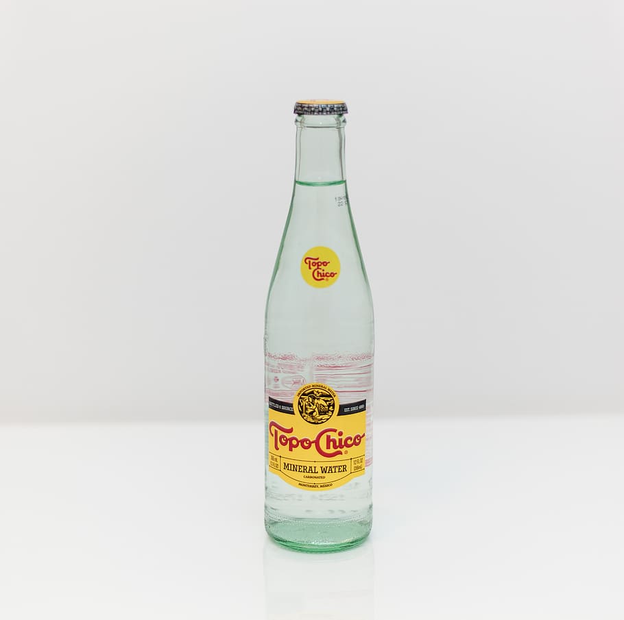 Topo Chico bottle on white surface, drink, beverage, pop bottle