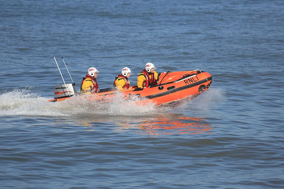 three people riding speedboat, clothing, apparel, vest, lifejacket