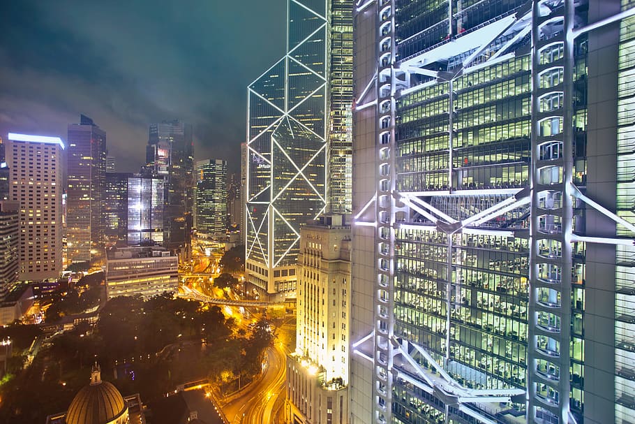 High rise glass buildings during night time with fully illuminated exterior