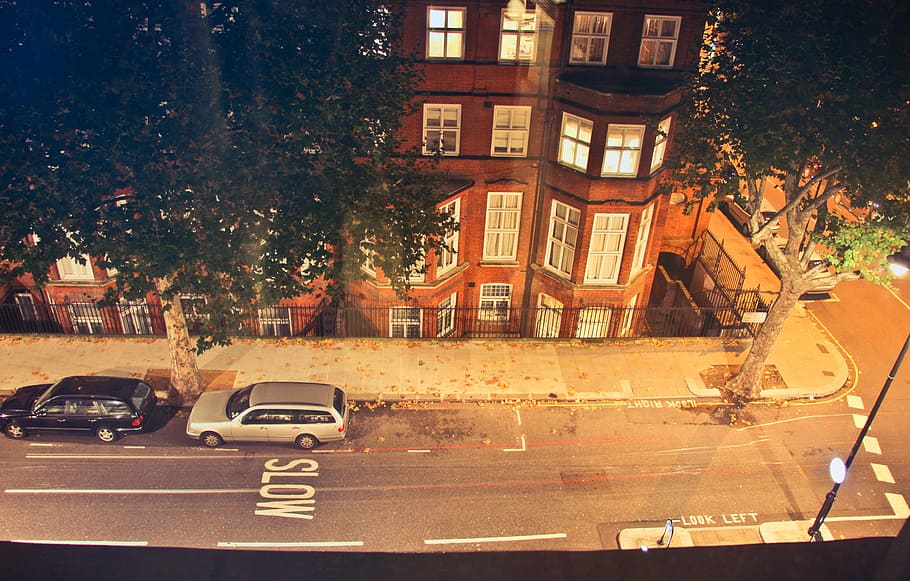 High Angle View Of Front facade of flat buildings in london with two cars parked at the road