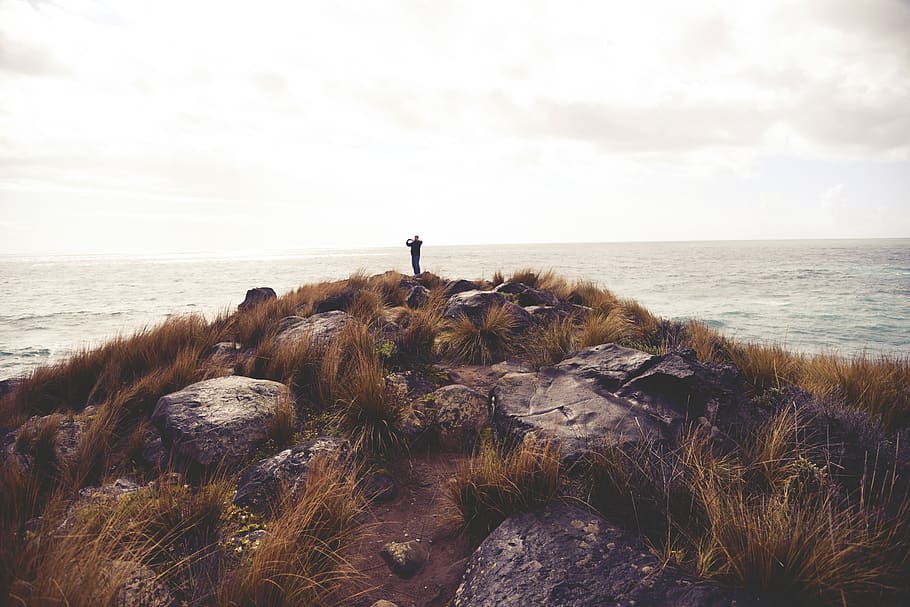 rocks, grass, cliff, coast, man, photography, sea, water, sky HD wallpaper
