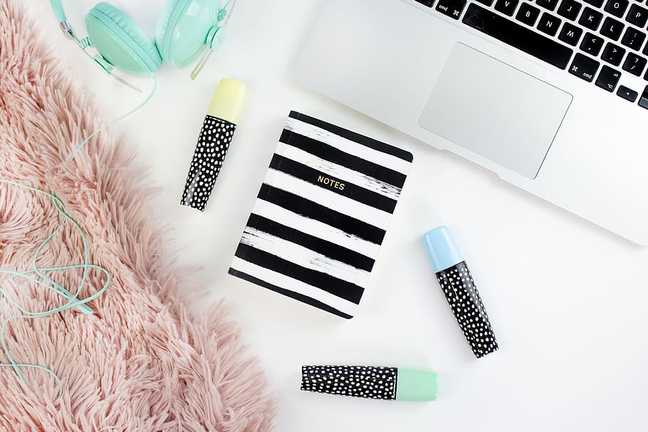teal full-size corded headphones beside silver MacBook, desk HD wallpaper