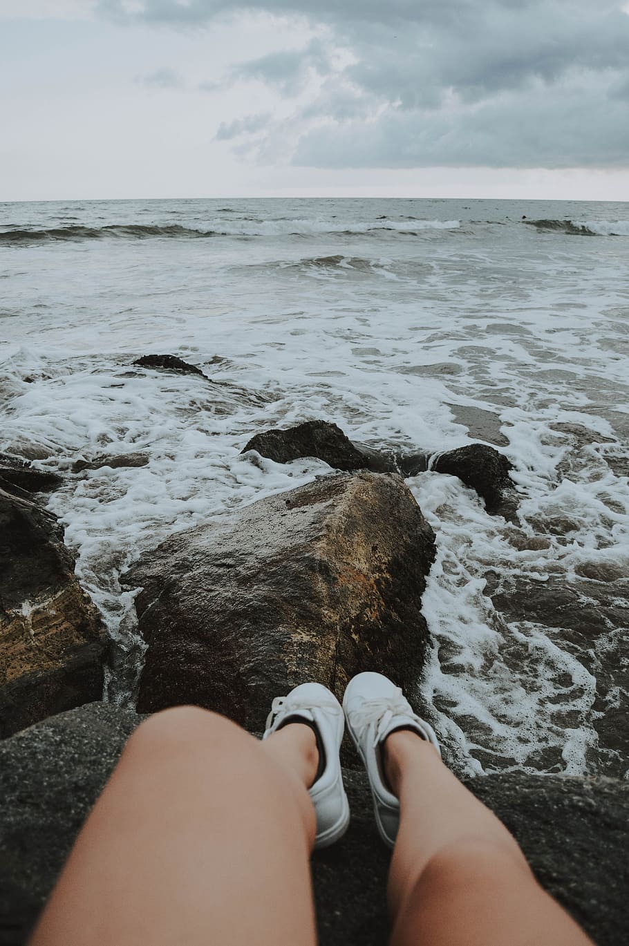 Person Sitting on Rocks, beach, clouds, coast, horizon, landscape HD wallpaper