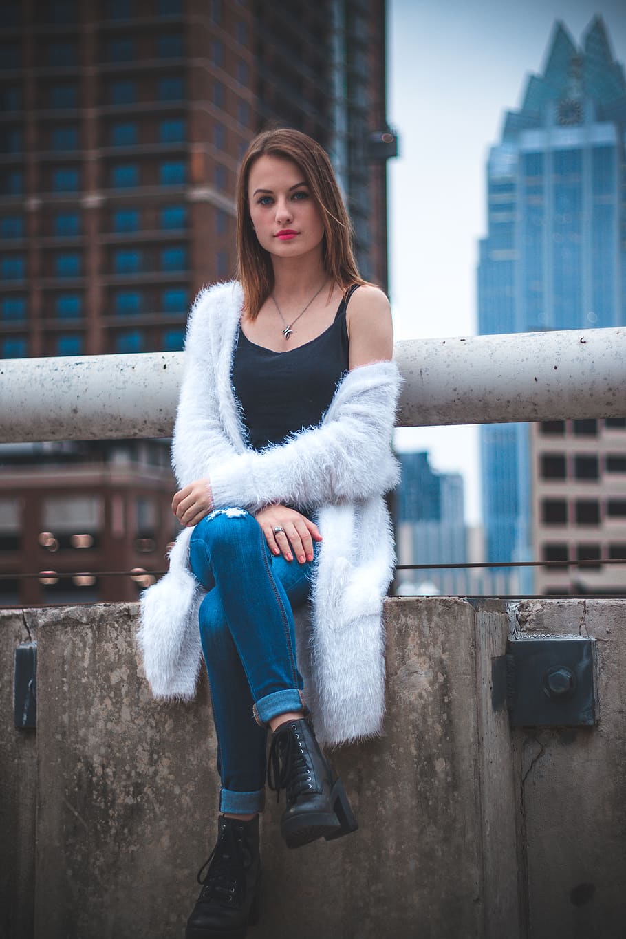 woman sitting on wall during daytime, apparel, clothing, shoe