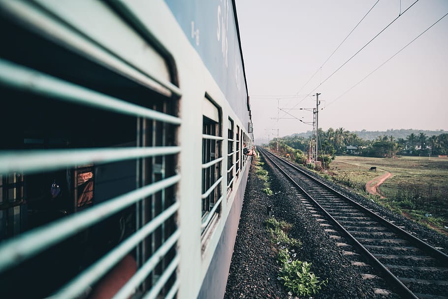 Perspective view of an Indian train coach window from while it is running with a photographer holding the camera outside