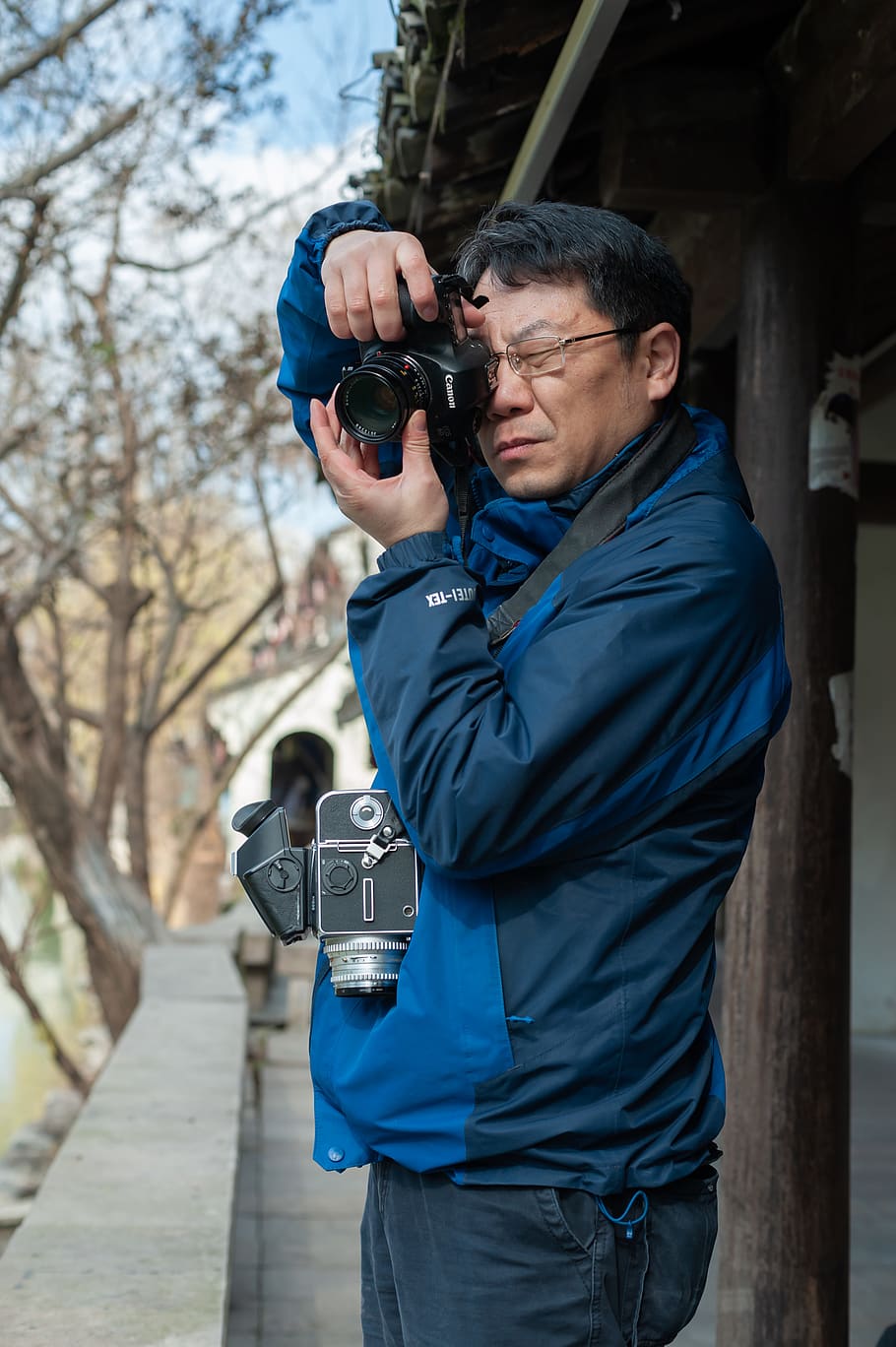 man using DSLR camera beside building, real people, technology HD wallpaper