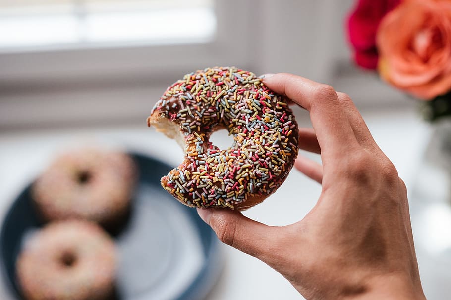 Person Holding Doughnut With Sprinkles, bite, breakfast, cake HD wallpaper