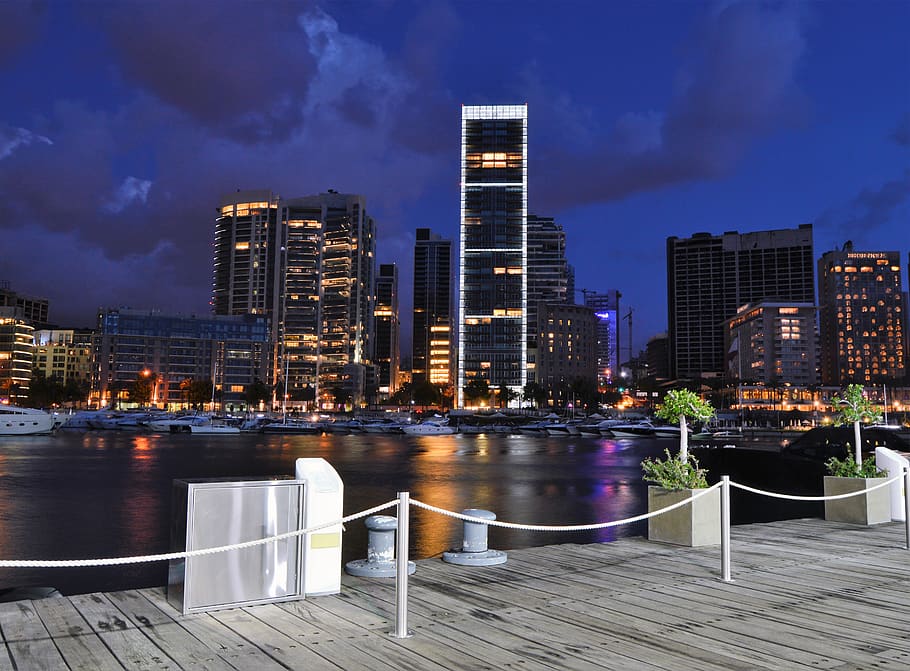 brown wooden dock near body of water at night, building, city
