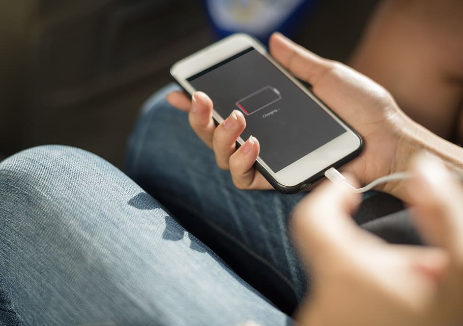 Person Holding Iphone, blur, charging, close-up, denim, fingers HD wallpaper