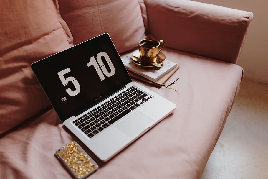 Workplace with a laptop on a pink couch, macbook, macbook pro HD wallpaper