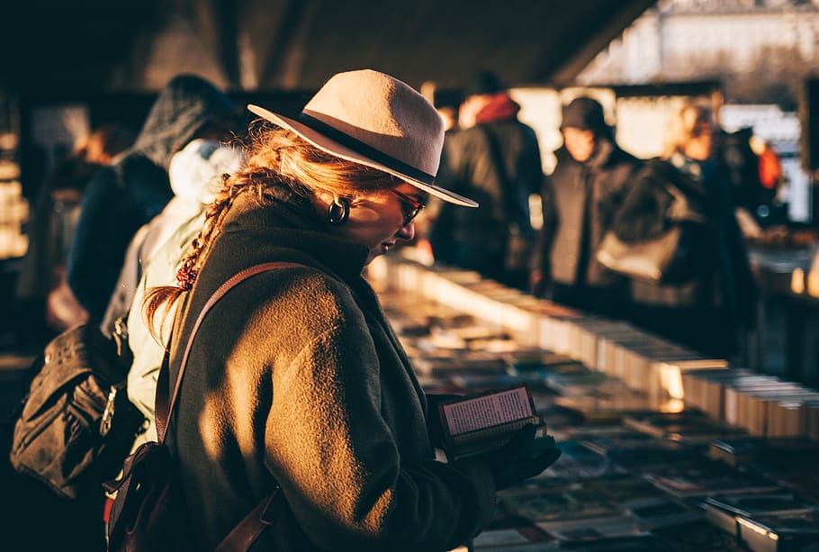 woman reading book, people, hat, person, human, market, stall, HD wallpaper