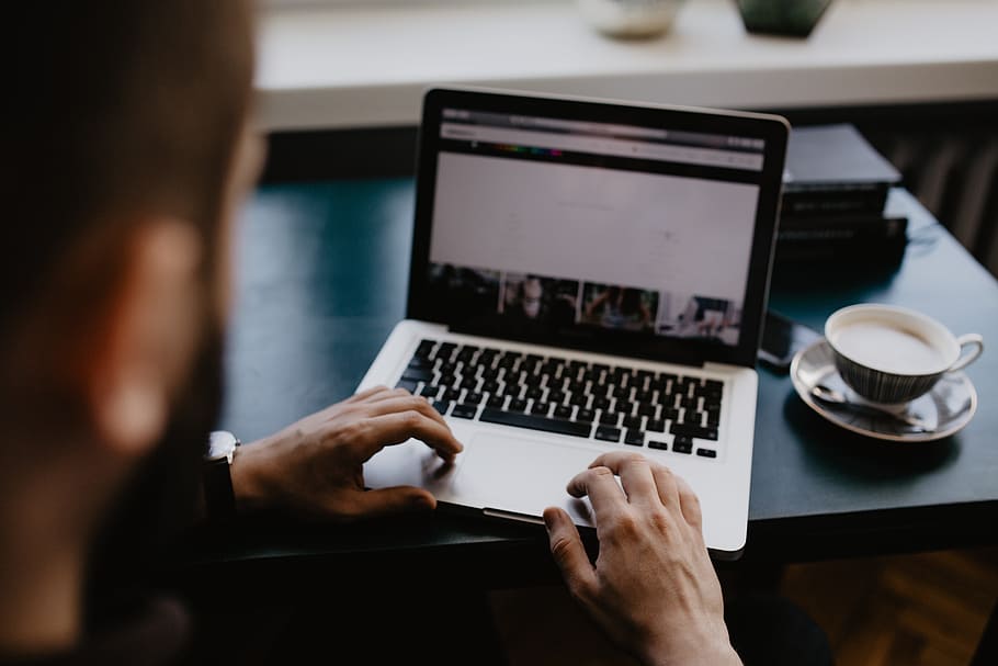 Male working with a laptop and a cup of coffee, desk, office, HD wallpaper