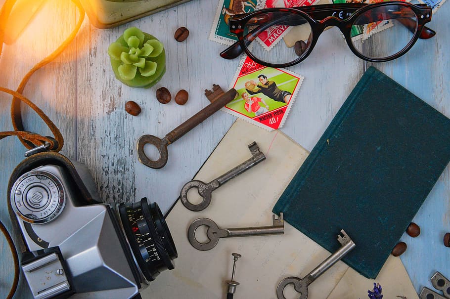 Four Gray Skeleton Keys Next to Gray Camera, Black Book, and Brown Framed Eyeglasses HD wallpaper