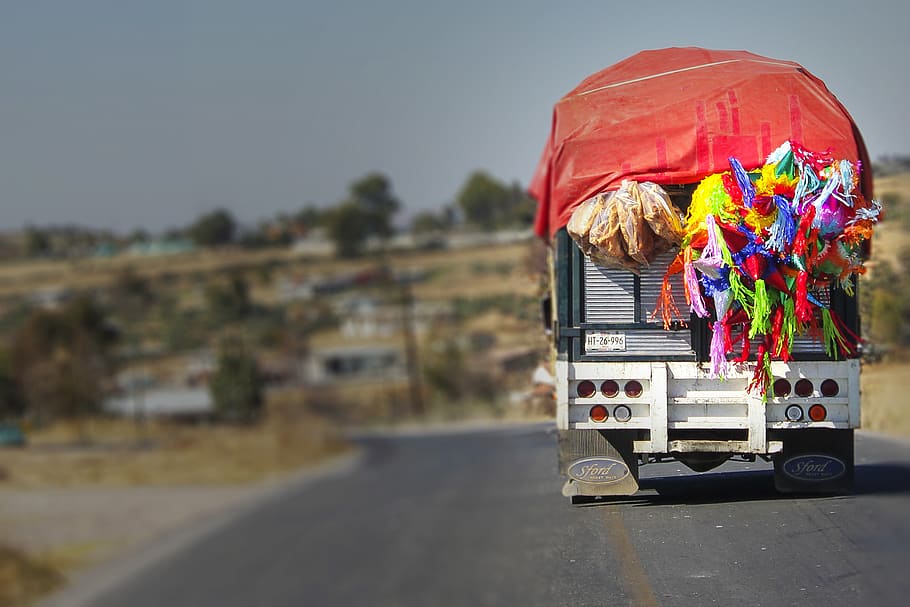 selective focus photography of truck carrying party hats, pinata