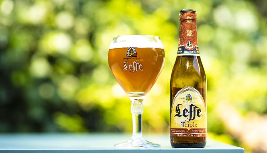 selective focus photo of Leffe triple glass bottle beside filled wine glass at daytime, HD wallpaper