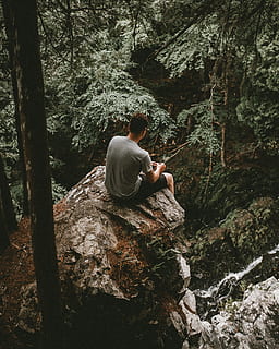 man sitting on gray rock near the cliff at daytime, person, tree HD wallpaper
