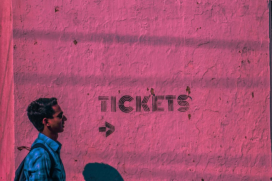 Man Wearing Blue Sports Shirt and Backpack Passing Through Pink Wall HD wallpaper
