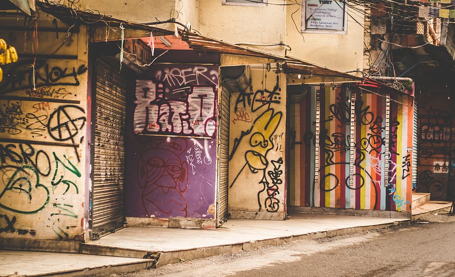 white concrete building with graffitis during daytime, art, painting