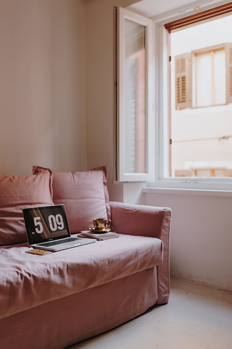 Workplace with a laptop on a pink couch, macbook, macbook pro HD wallpaper
