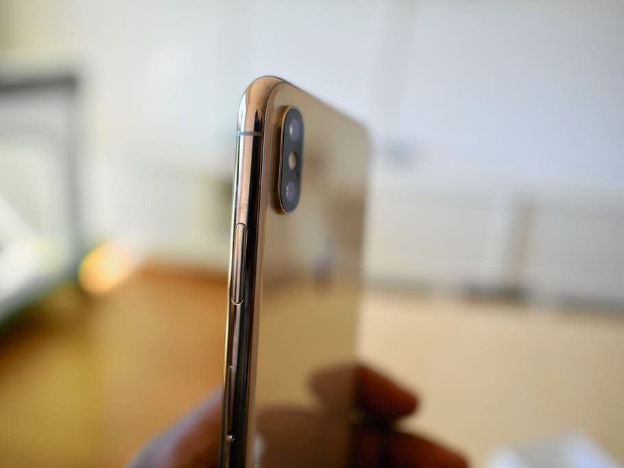 gold smartphone, focus on foreground, indoors, close-up, metal HD wallpaper