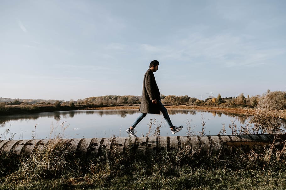Man Walking on Concrete Pavement Near Body of Water, daylight HD wallpaper