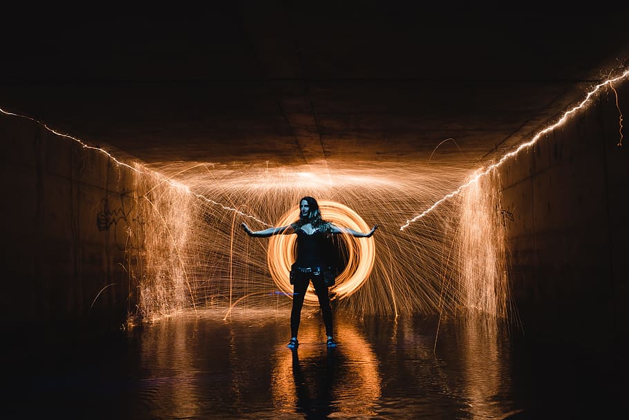 standing woman with background of long exposure photo of orange light HD wallpaper