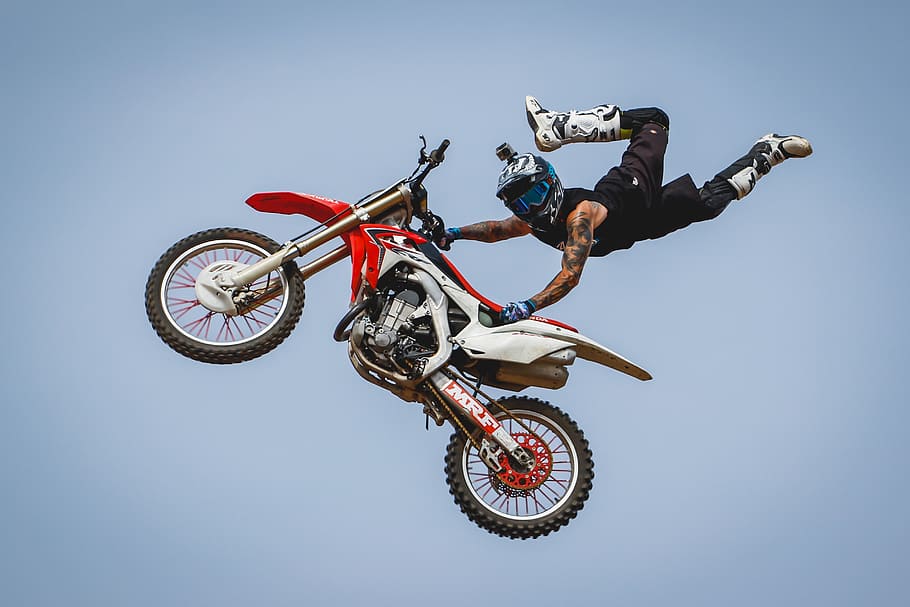 male rider with arm tattoos riding dirt bike doing trick on mid air during daytime, HD wallpaper