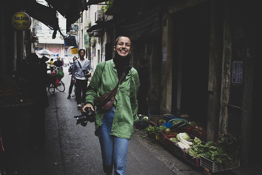 Smiling Woman Walking Beside Display Vegetables, camera, city HD wallpaper
