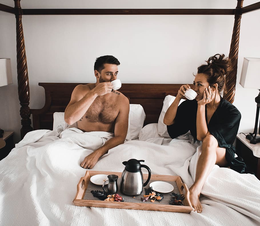 man drinking some coffee beside woman, male, female, bed, bedclothes