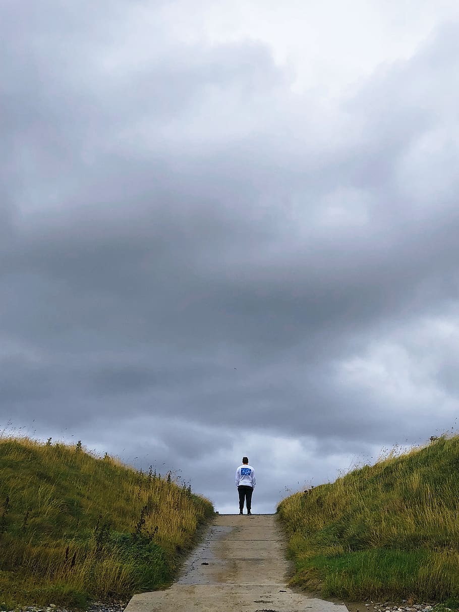 person standing between grass field, dirt road, gravel, path HD wallpaper