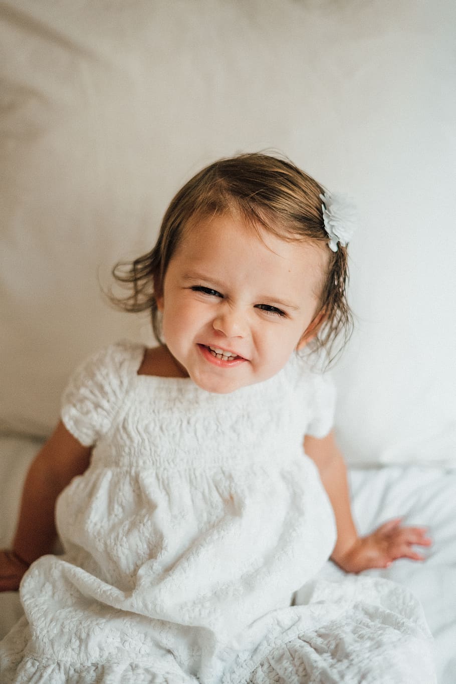 girl smiling while sitting on bedspread, childhood, happiness HD wallpaper